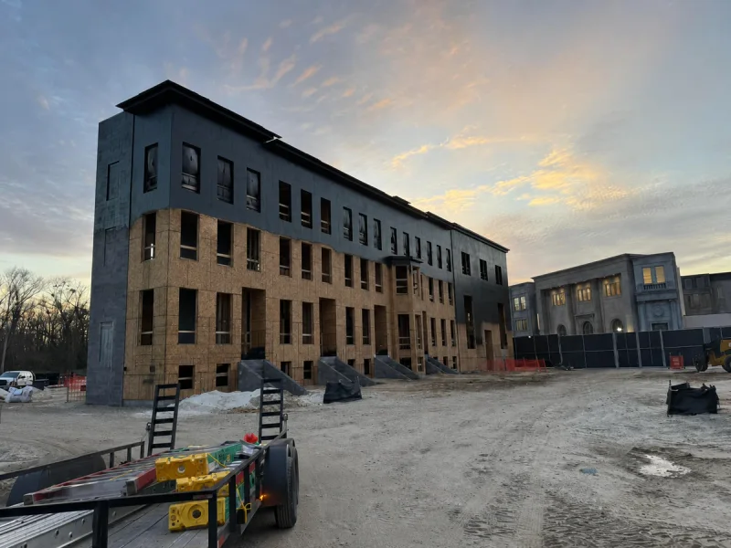 The same elevation after painting, dark charcoal coating carried across the upper floors and corner tower