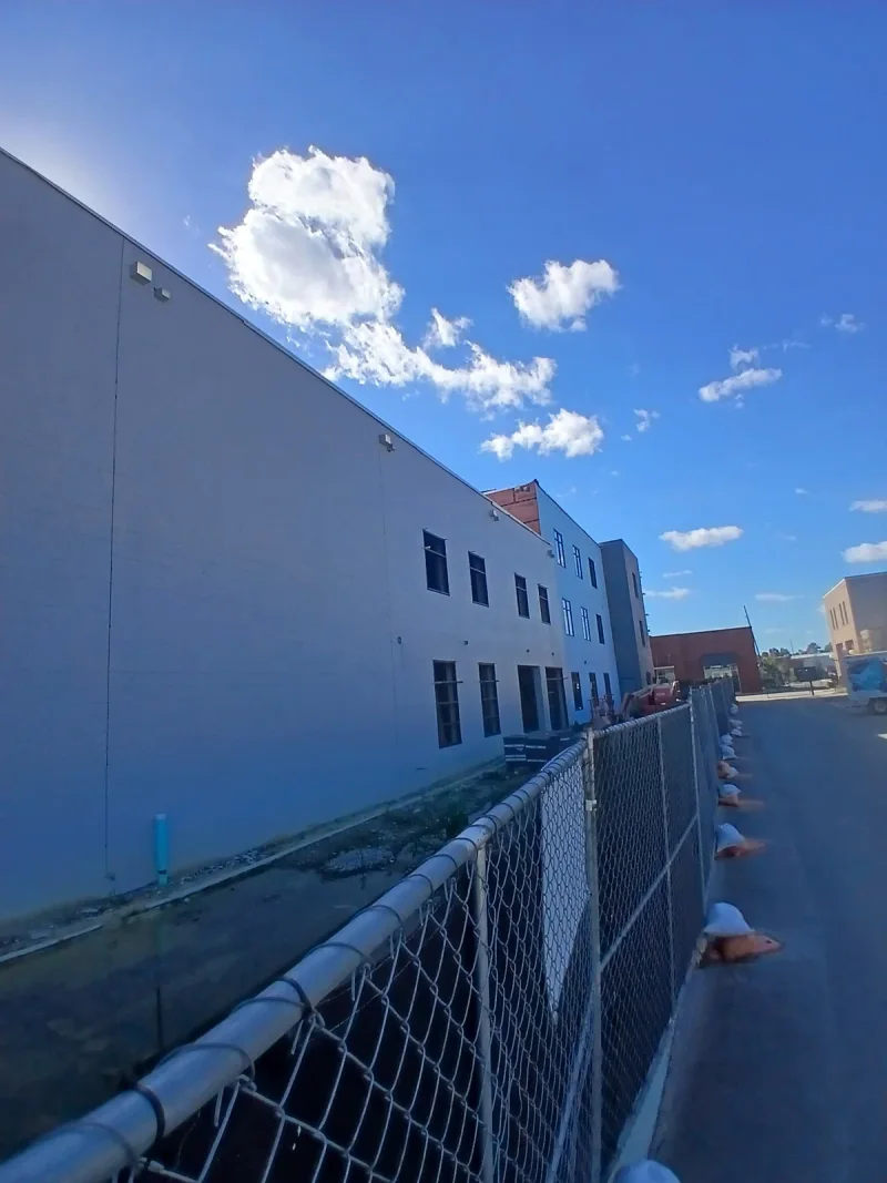 Long side elevation coated in pale blue-grey, running back toward the rear of the site