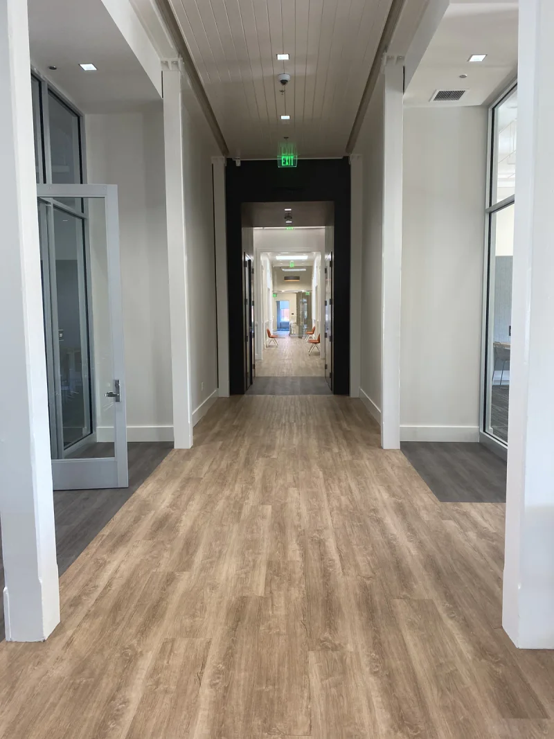 Office hallway with glazed doors, crisp painted trim and a beadboard ceiling overhead