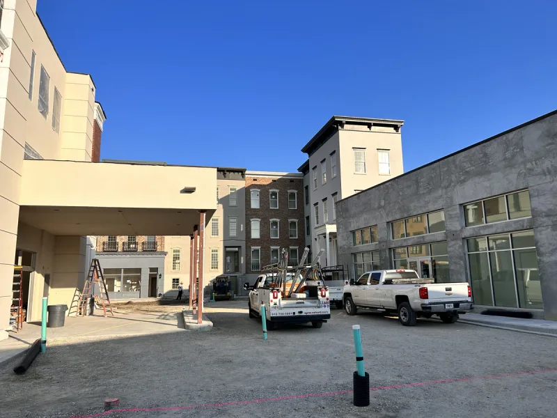 Painted portico entrance and canopy at the centre of the block, still an active work site