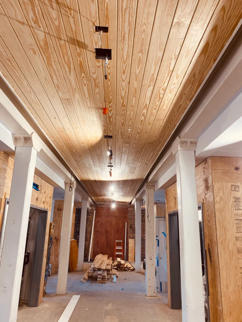Pine ceiling boards in place over a colonnaded walkway still under construction