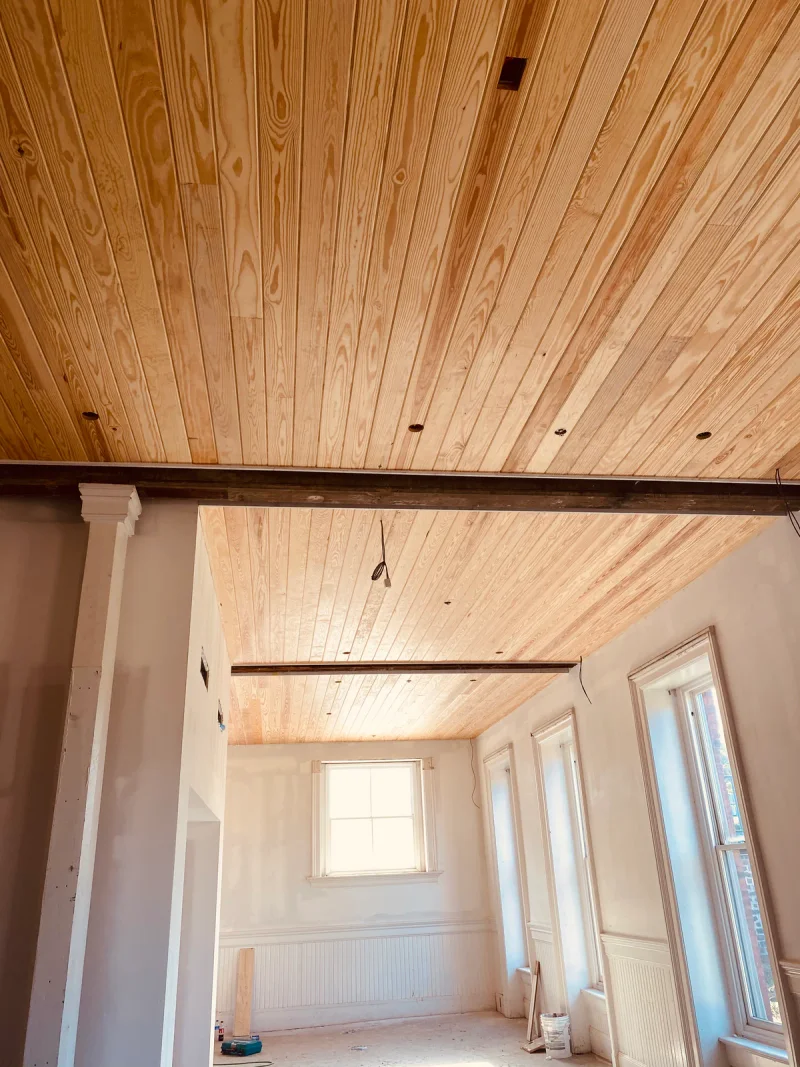 New pine plank ceiling fitted above white-primed walls and a classical painted column